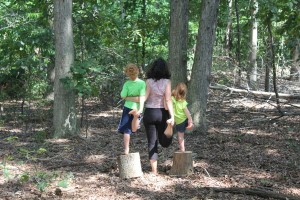 mom and two kids yoga in the woods